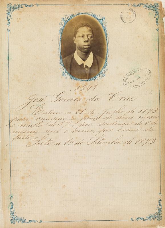 Página do livro Galeria dos Condenados – da Biblioteca Nacional. Documento do século XIX contendo um retrato oval de José Gomes da Cruz, homem negro de terno e gravata, cercado por uma moldura decorativa azul. Abaixo, um texto manuscrito em tinta marrom registra que José entrou na prisão em 28 de julho de 1843 para cumprir pena de dois meses por furto, saindo em 10 de setembro do mesmo ano.